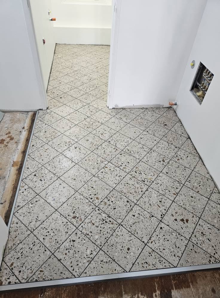 Pose de carrelage de plusieurs formats différents pour cet appartement, sur chape liquide et natte de désolidarisation pour plancher bois.